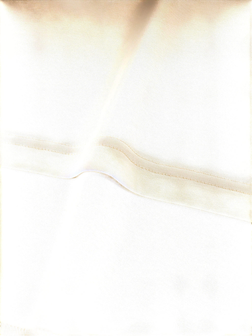 Close-up of VaultWear cream-colored cotton t-shirt fabric showing detailed stitching and soft texture