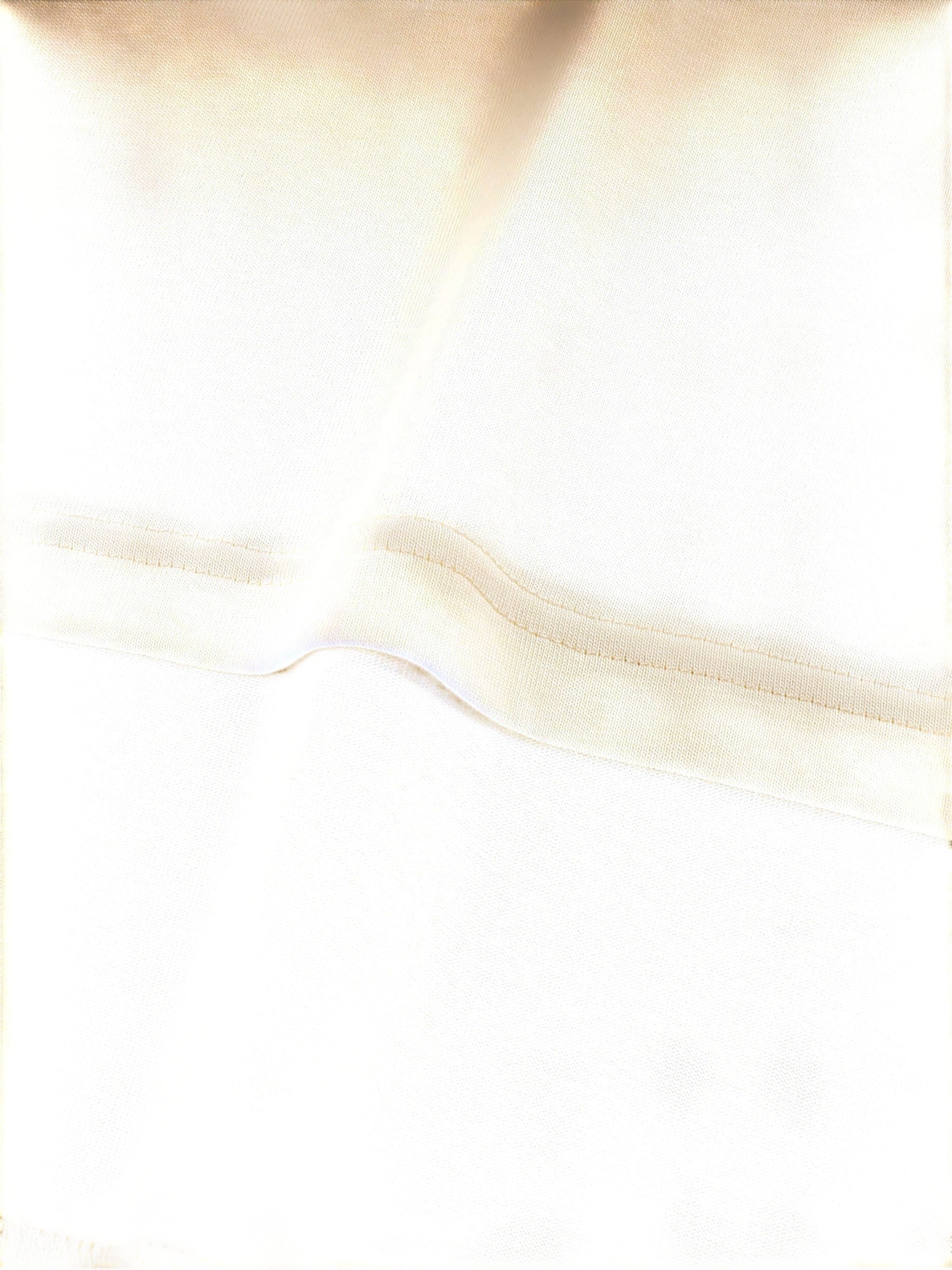 Close-up of VaultWear cream-colored cotton t-shirt fabric showing detailed stitching and soft texture