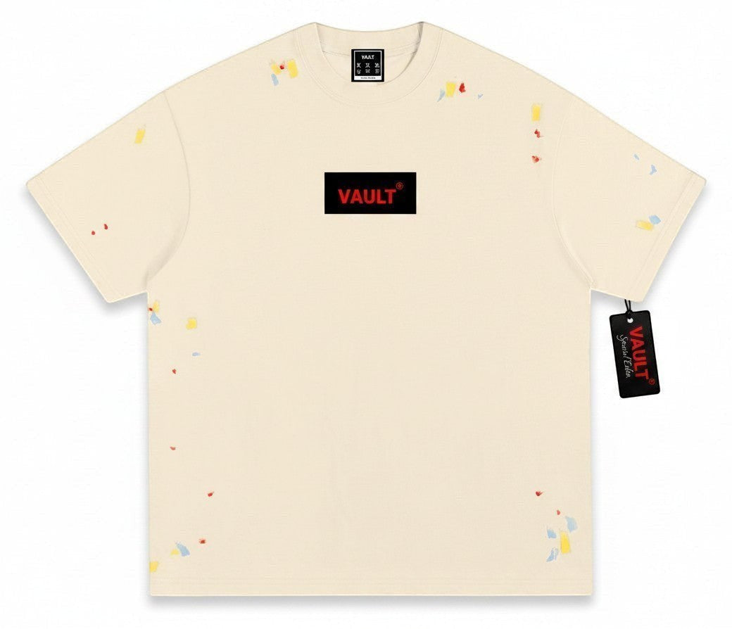 VaultWear cream cotton crewneck t-shirt featuring a black logo patch with red text and multi-colored paint splatters.