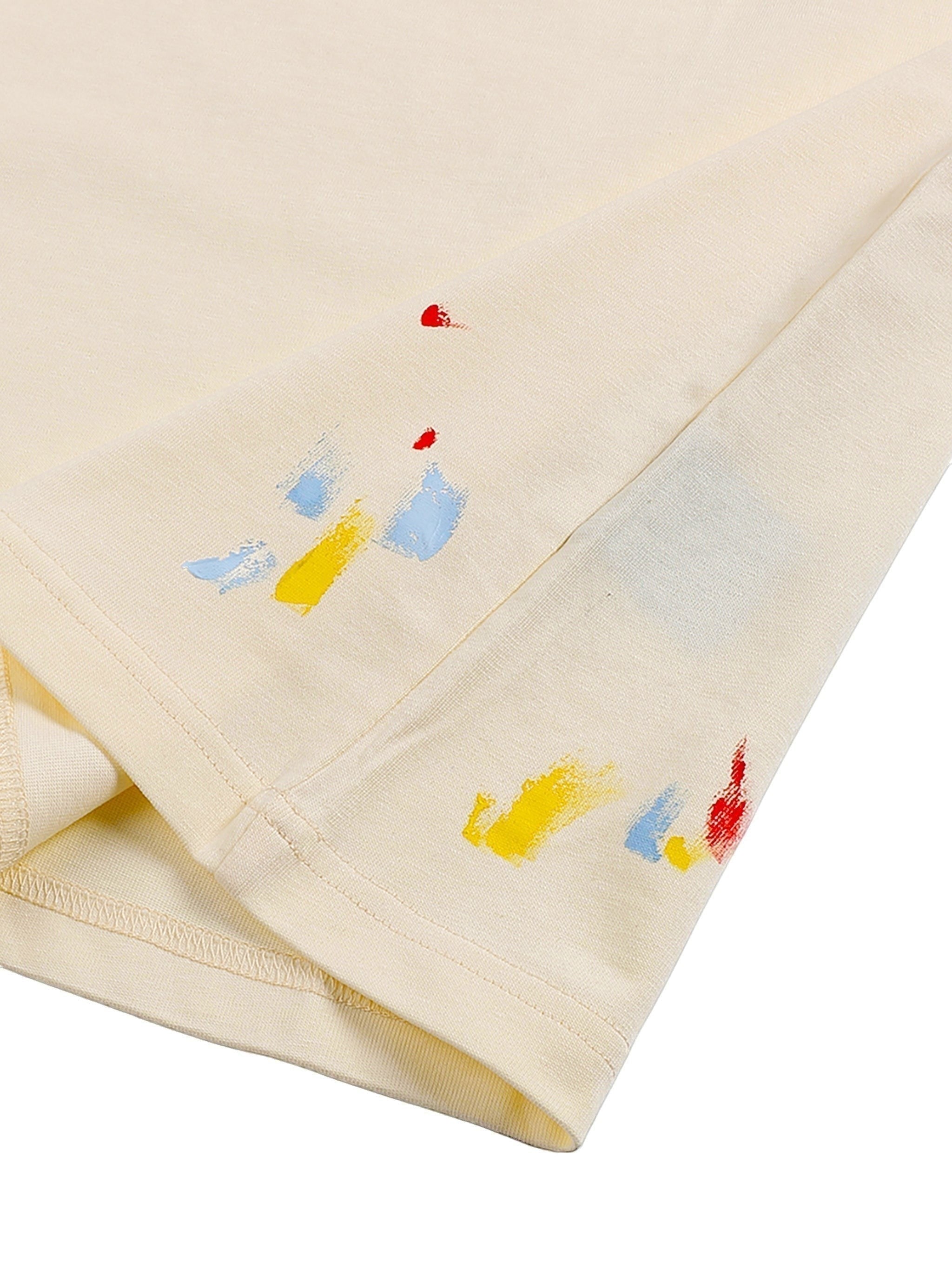 VaultWear cream cotton t-shirt featuring multi-colored paint splatter details on the hem